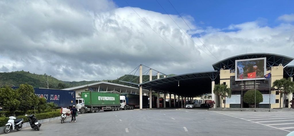 Laos border-crossing checkpoint. Cargo containers await clearance from customs officers.